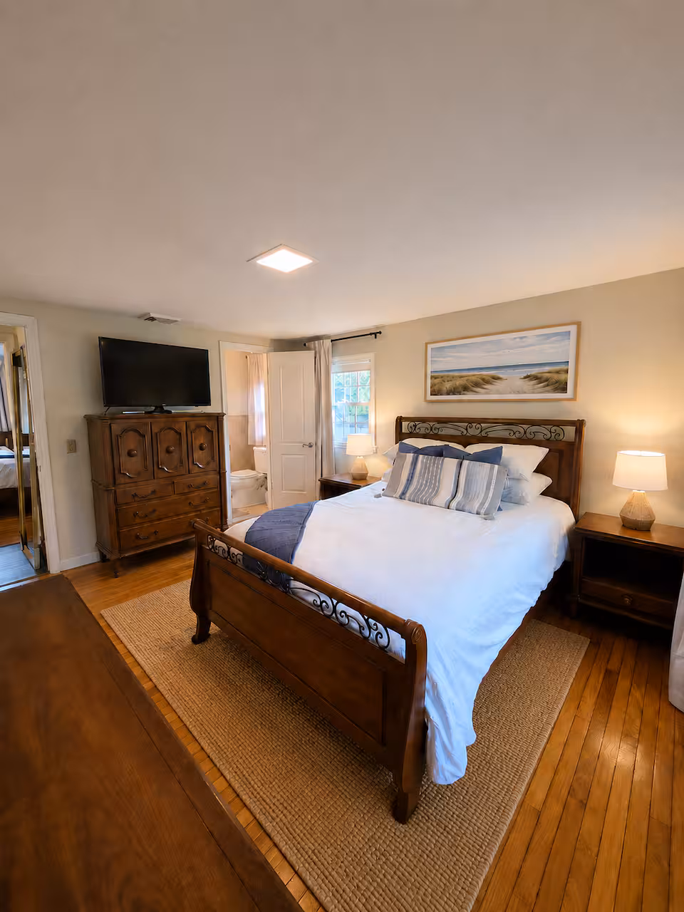 Primary suite — queen bed with ensuite half bath